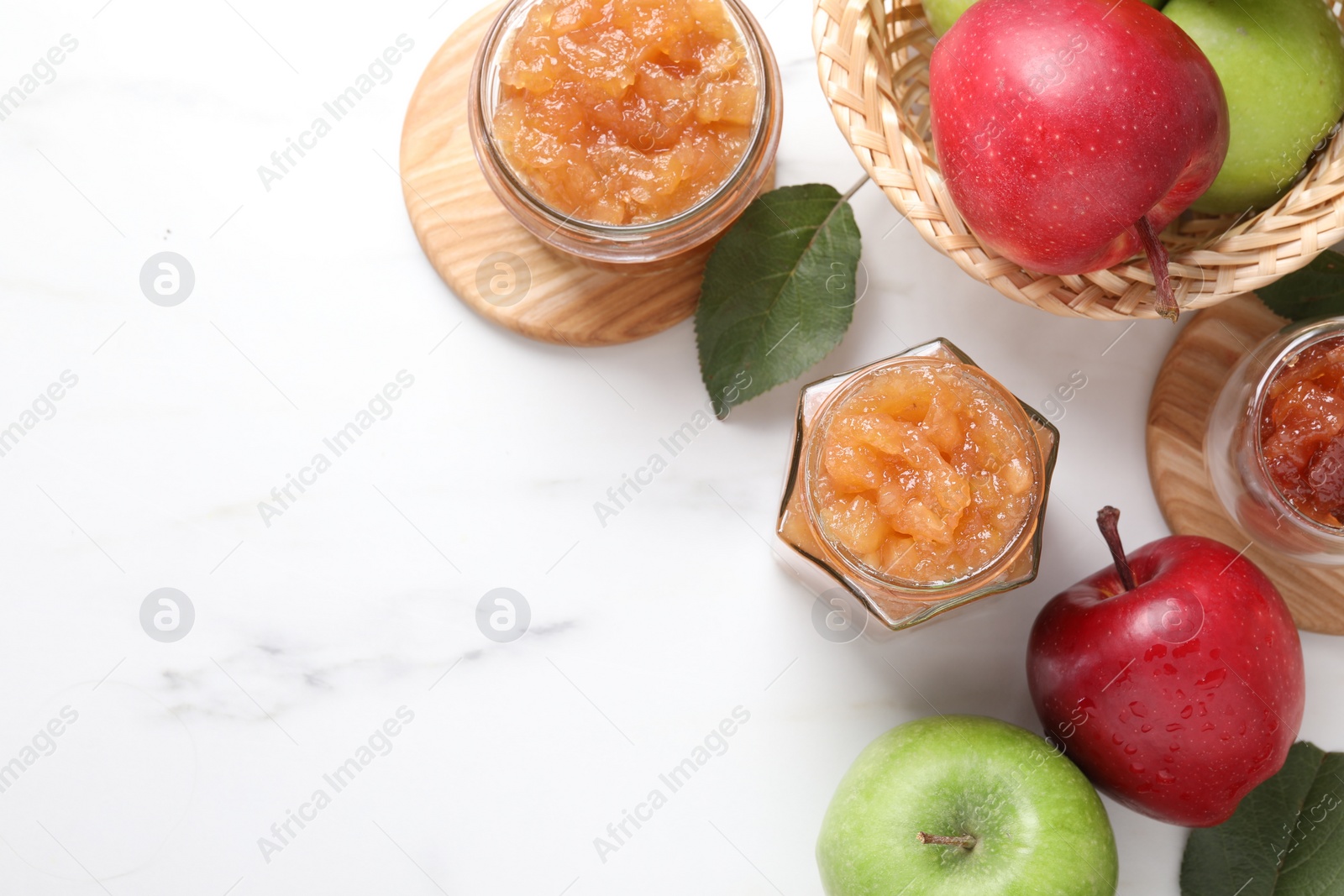 Photo of Delicious apple jam and fresh fruits on white table, flat lay. Space for text