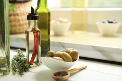 Photo of Different cooking oils and ingredients on white wooden table indoors