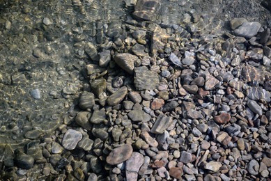 Photo of River coast with stones and pebbles, top view
