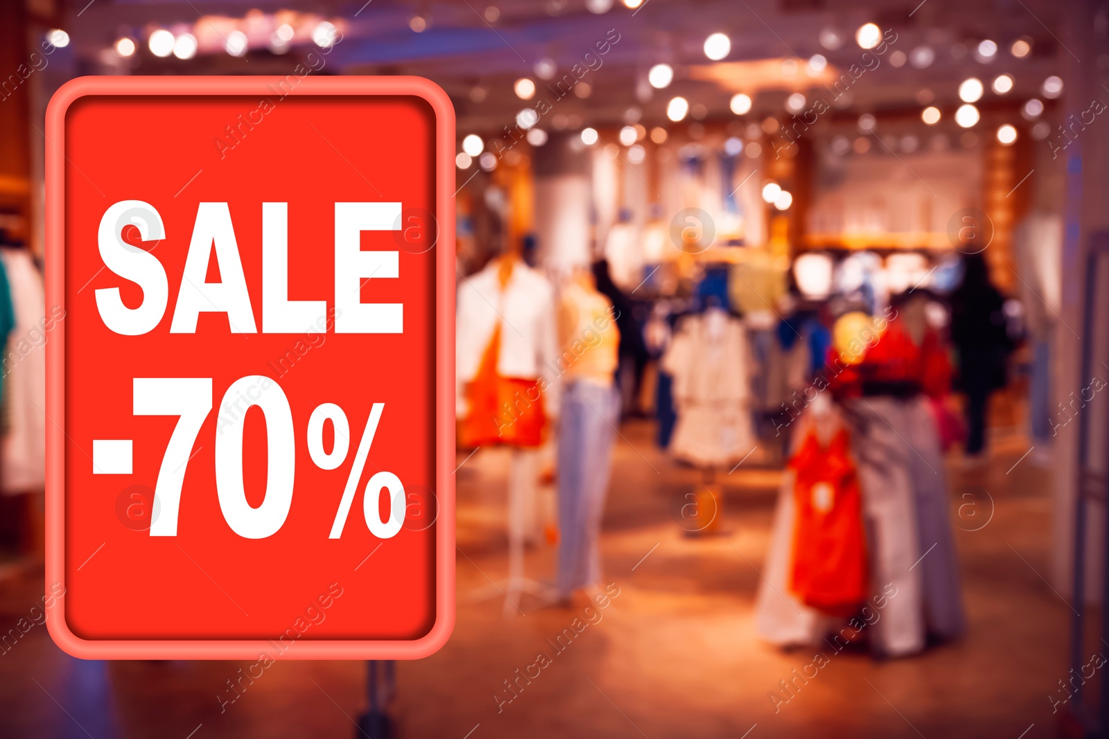 Image of Sale sign and blurred view of fashion store with clothes