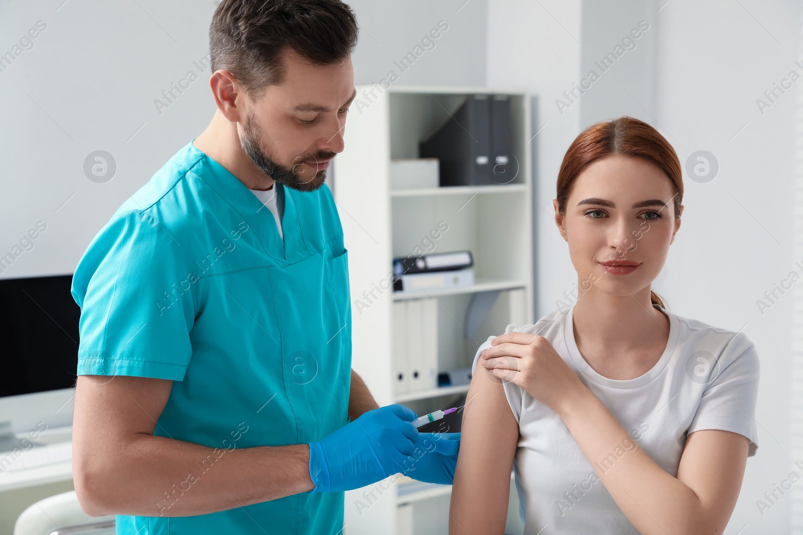 Photo of Doctor giving hepatitis vaccine to patient in clinic