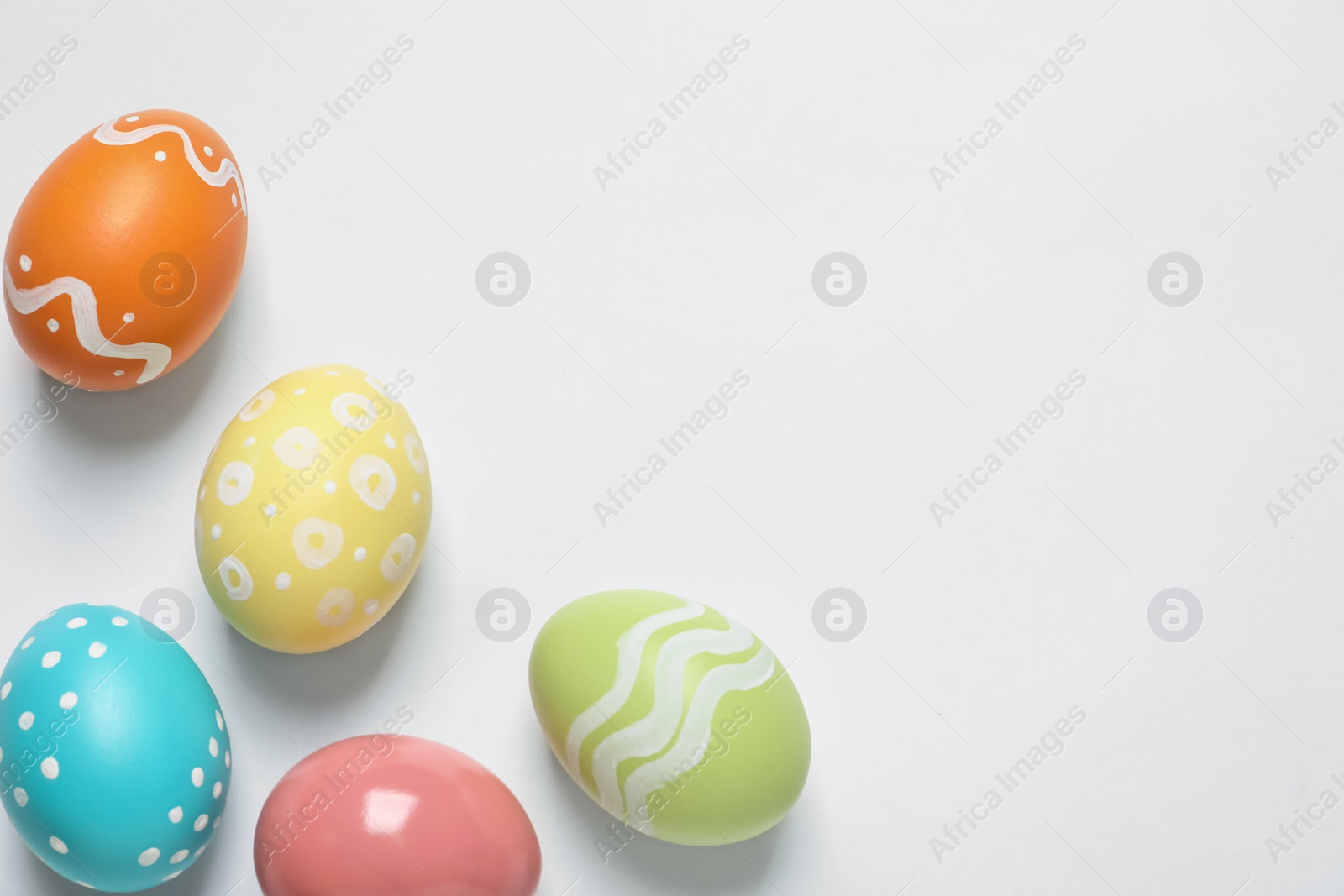 Photo of Colorful painted Easter eggs on white background, top view