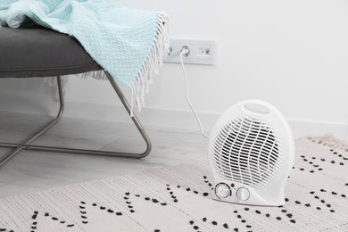 Photo of Electric fan heater on floor at home. Space for text