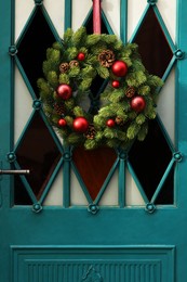 Beautiful Christmas wreath hanging on turquoise door