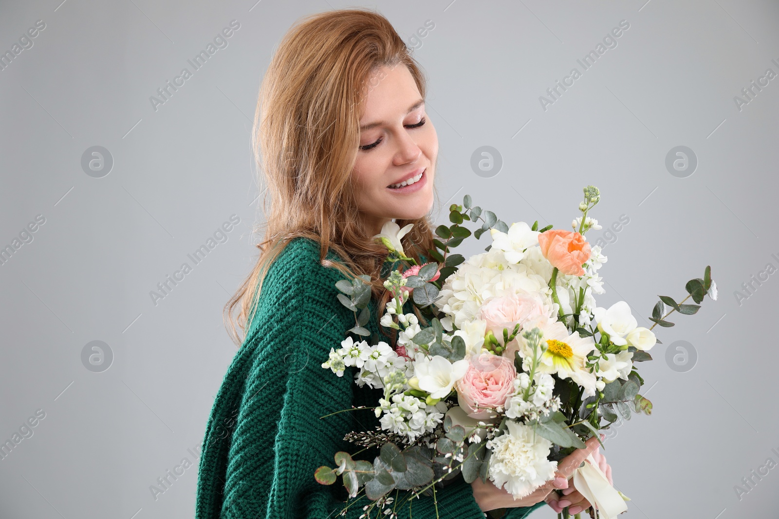 Photo of Beautiful woman with bouquet of flowers on grey background