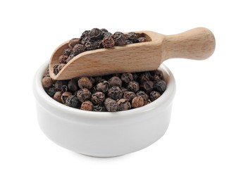 Photo of Aromatic spice. Many black peppercorns in bowl and scoop isolated on white