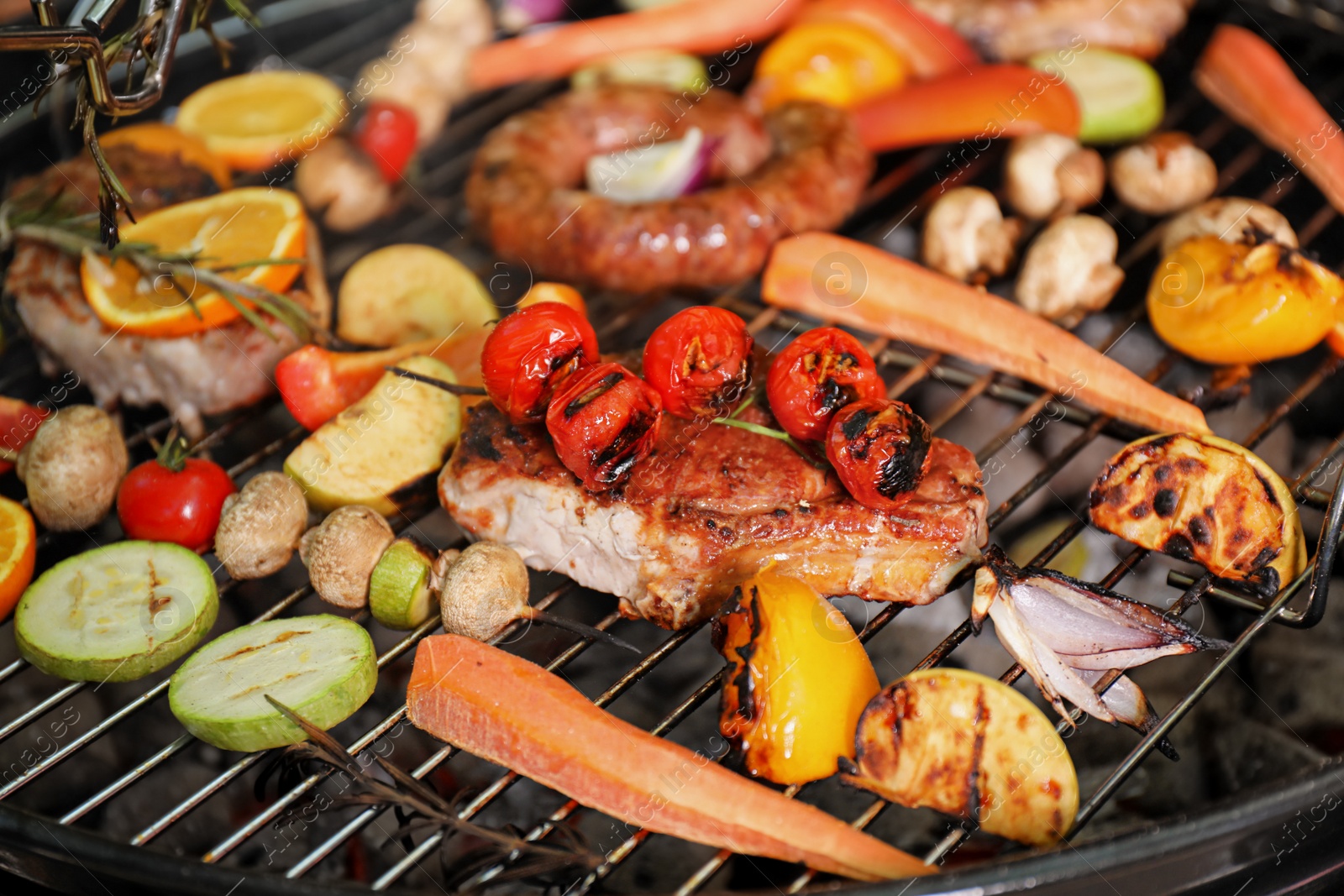 Photo of Barbecue grill with delicious cooked meat and vegetables, closeup