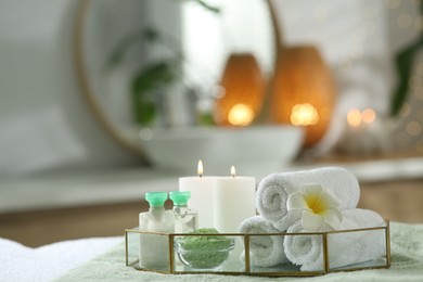 Photo of Composition with different spa products and burning candles on table indoors. Space for text