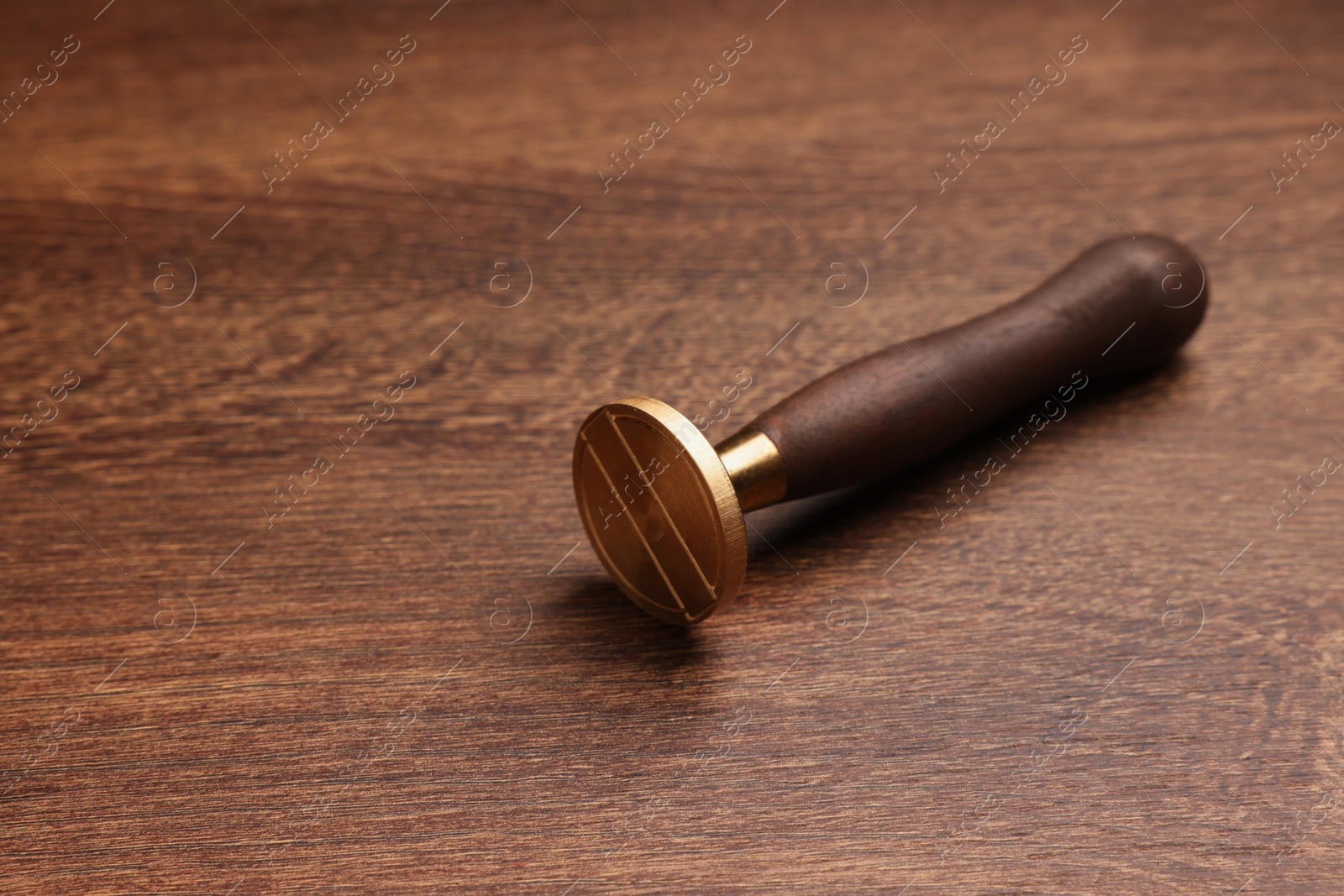 Photo of One stamp tool on wooden table, closeup. Space for text