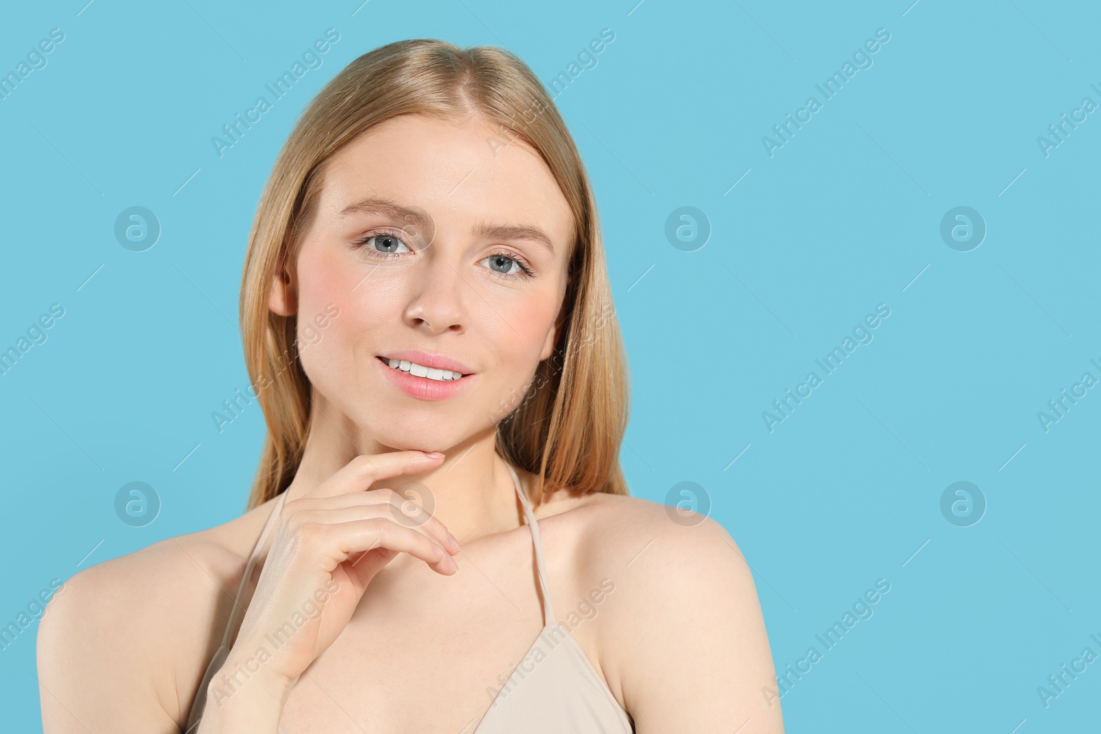 Photo of Beautiful young woman posing on light blue background, space for text