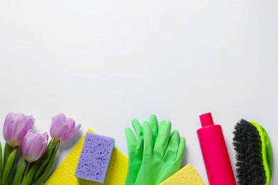 Spring cleaning. Detergent, flowers and tools on white background, flat lay. Space for text