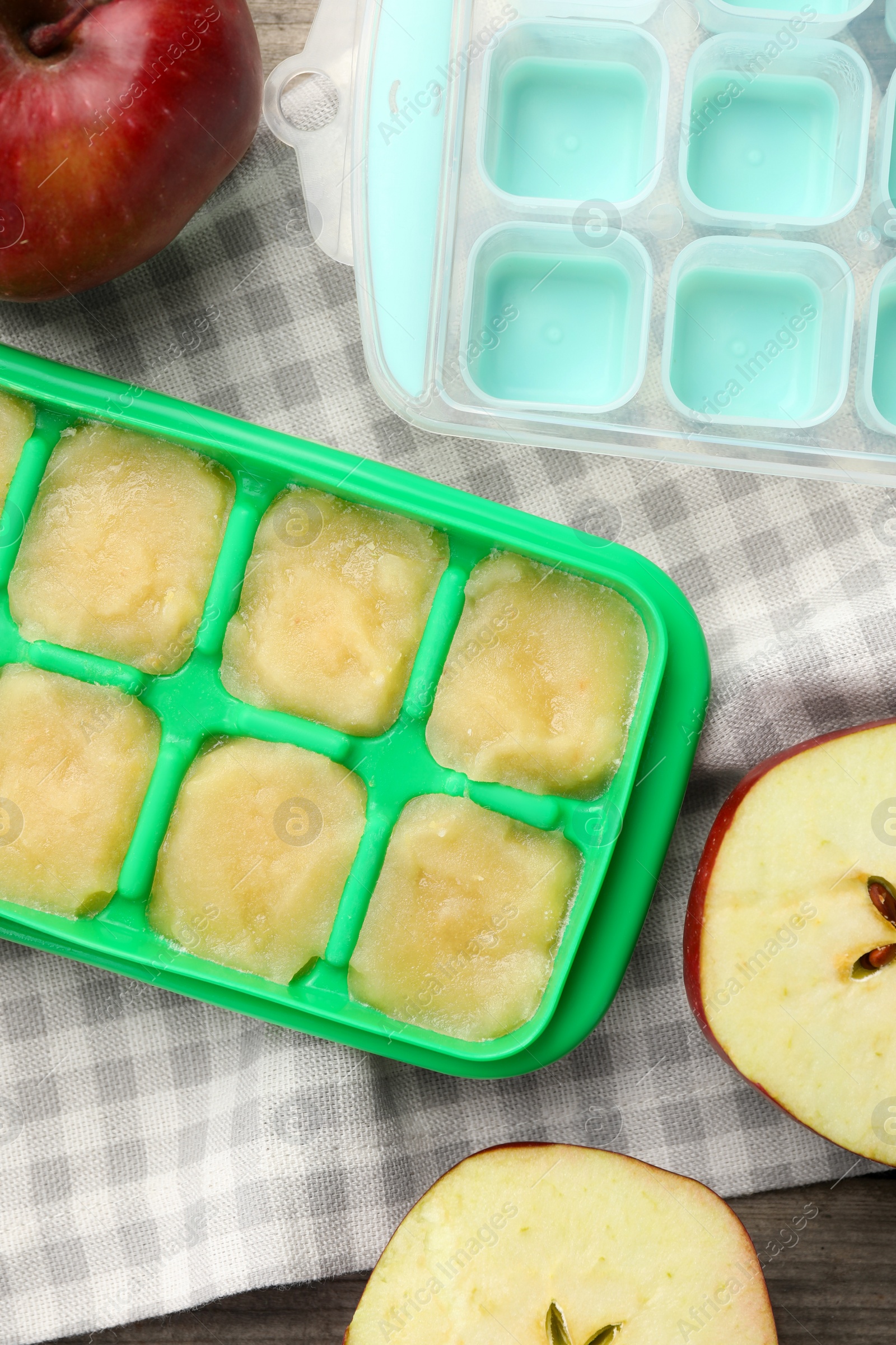 Photo of Apple puree in ice cube tray with ingredients on table, flat lay