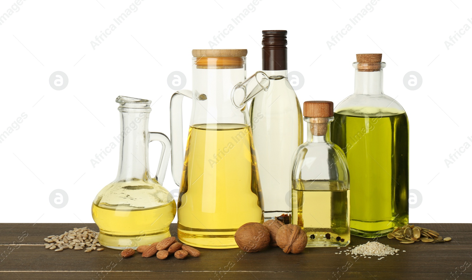 Photo of Vegetable fats. Different cooking oils and ingredients on wooden table against white background