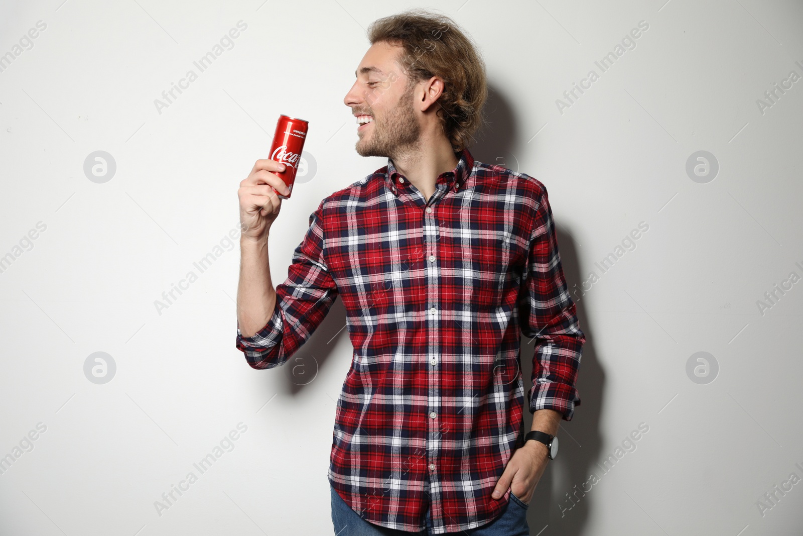 Photo of MYKOLAIV, UKRAINE - NOVEMBER 28, 2018: Young man with Coca-Cola can on white background