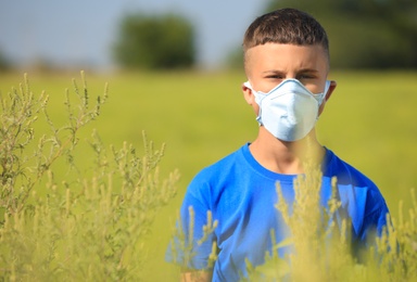 Photo of Little boy suffering from ragweed allergy outdoors