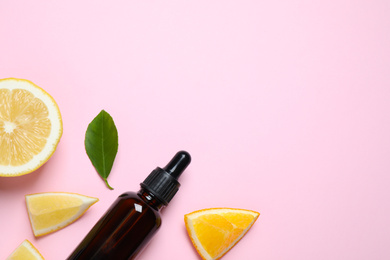 Photo of Flat lay composition with bottle of citrus essential oil on pink background. Space for text