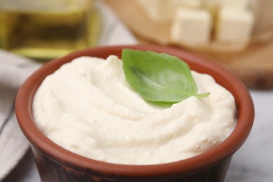 Photo of Delicious tofu sauce and basil leaf in bowl on table, closeup