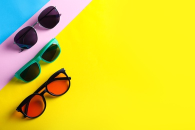 Many stylish sunglasses on color background, flat lay. Space for text