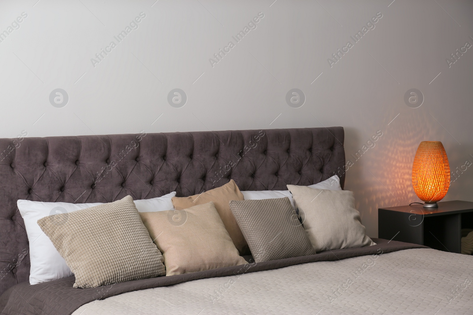 Photo of Large comfortable bed near light wall in modern room interior