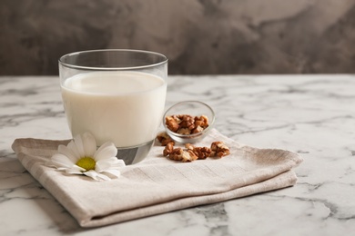 Photo of Glass with milk and nuts on table