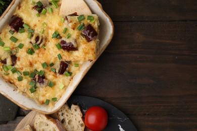 Photo of Tasty sausage casserole served on wooden table, flat lay. Space for text