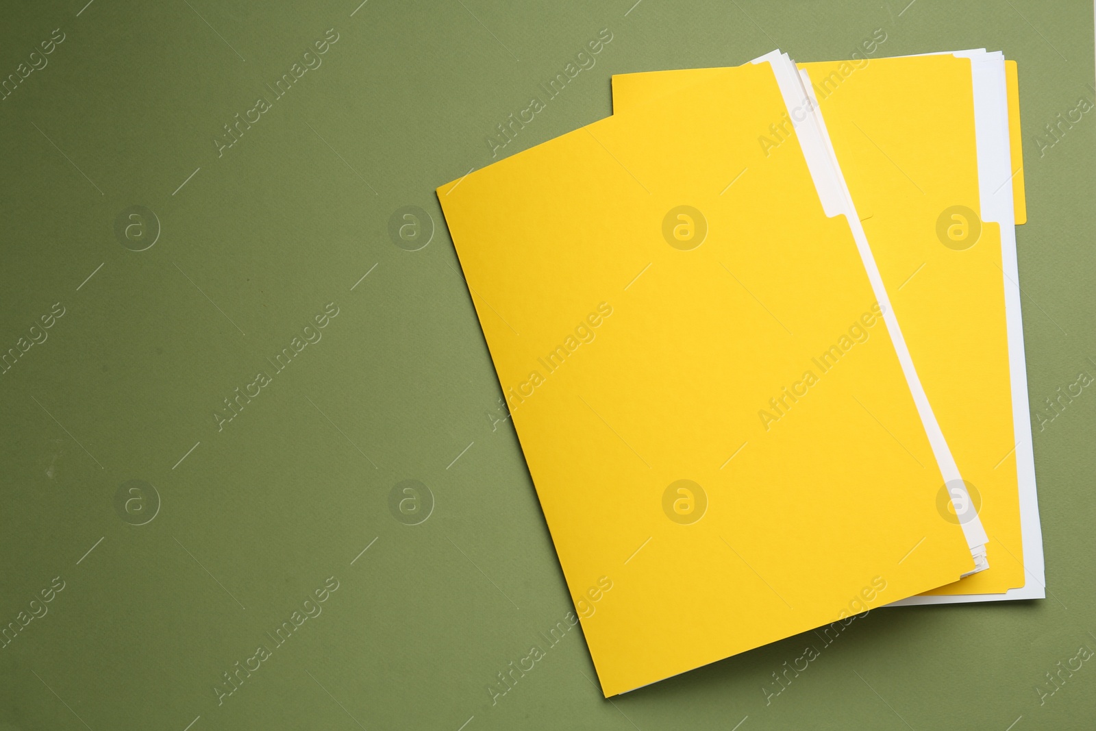 Photo of Yellow files with documents on olive background, top view. Space for text