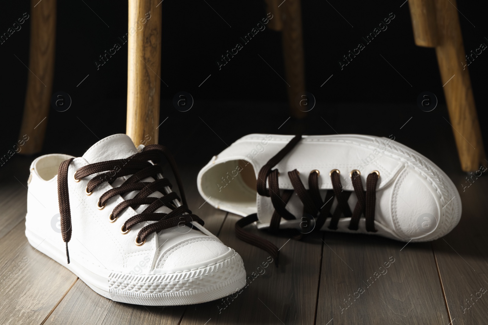 Photo of Pair of stylish shoes with brown laces on wooden floor indoors