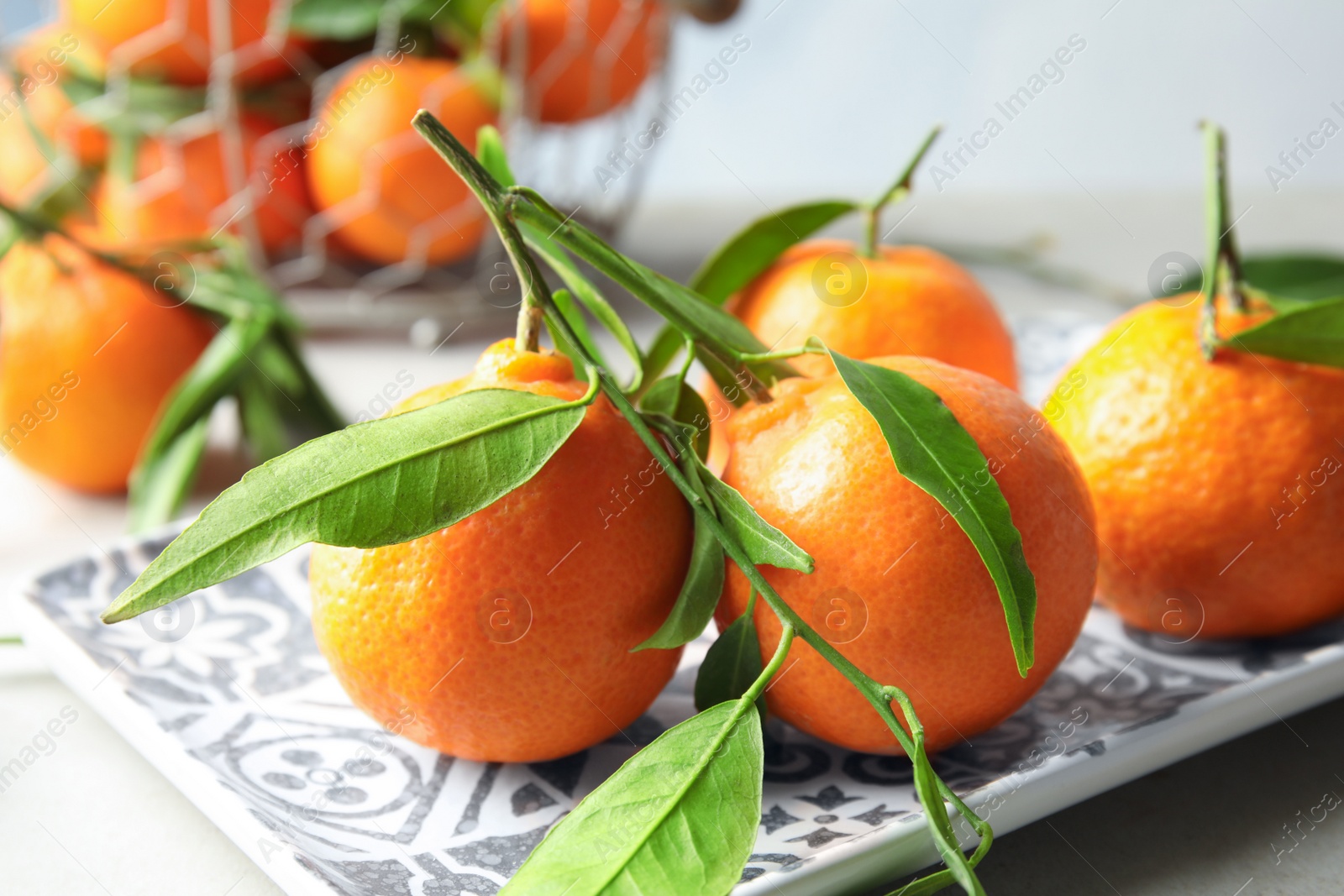 Photo of Plate with tasty ripe tangerines on table