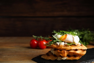 Delicious sandwich with arugula and egg on wooden table. Space for text