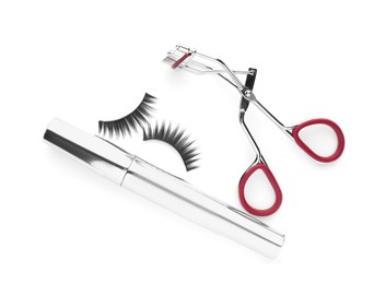 Photo of False eyelashes, curler and mascara on white background, top view