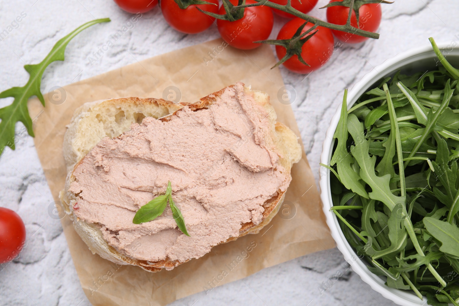 Photo of Delicious liverwurst sandwich with basil and ingredients on white textured table, flat lay