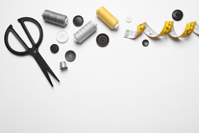 Photo of Composition with scissors and other sewing accessories on white background, top view