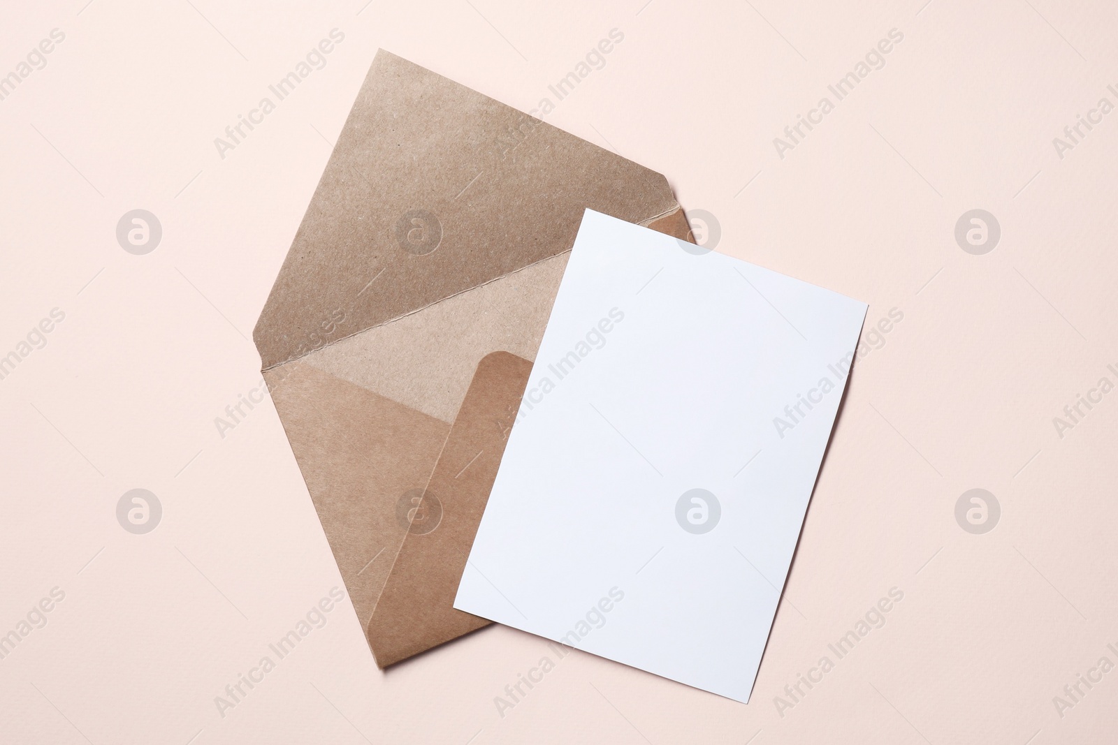 Photo of Letter envelope and card on beige background, top view. Space for text