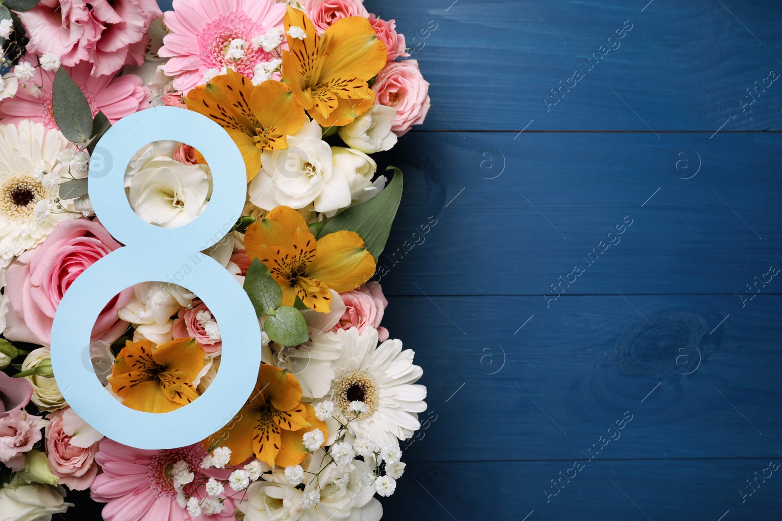 Photo of 8 March greeting card design with beautiful flowers on blue wooden table, flat lay and space for text. International Women's day