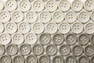 Photo of Many plastic sewing buttons on white background, top view