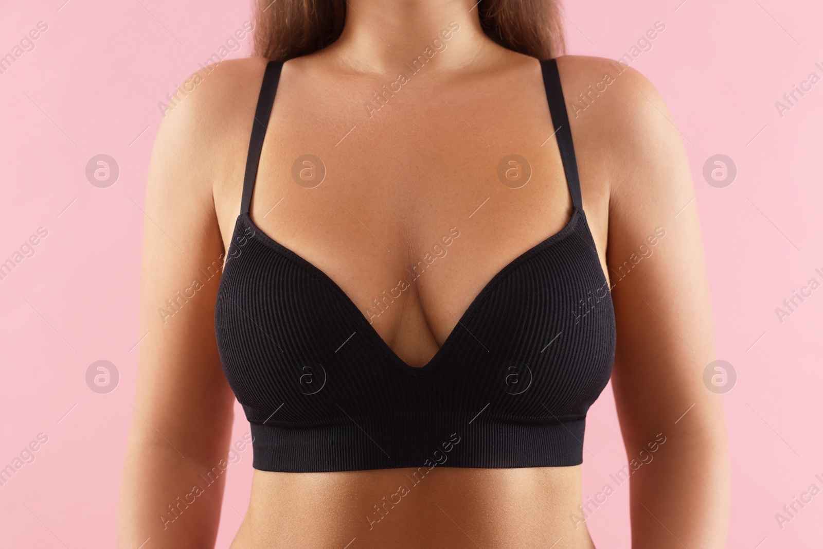 Photo of Woman with beautiful breast on pink background, closeup