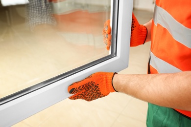 Construction worker installing new window in house