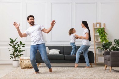 Photo of Happy family dancing and having fun in living room