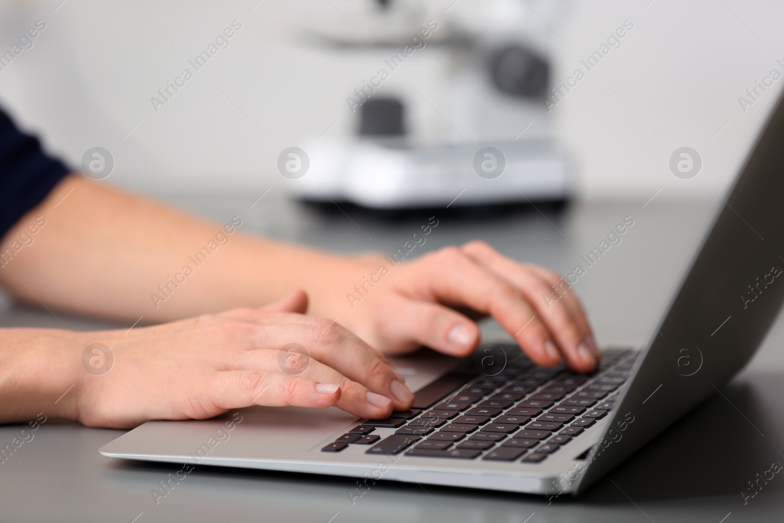 Photo of Female student working with laptop at table. Medical education