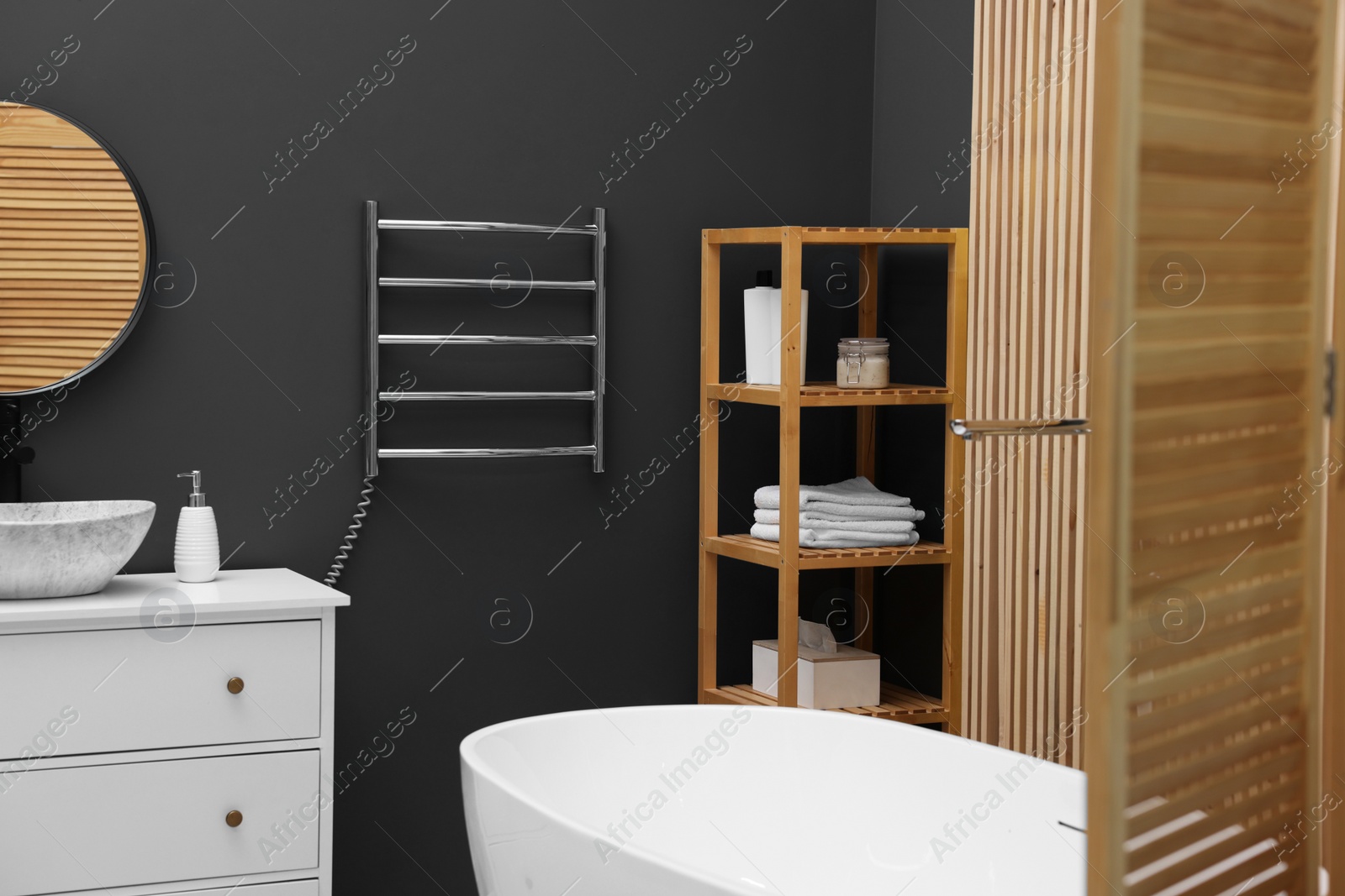 Photo of Stylish bathroom interior with heated towel rail and modern furniture