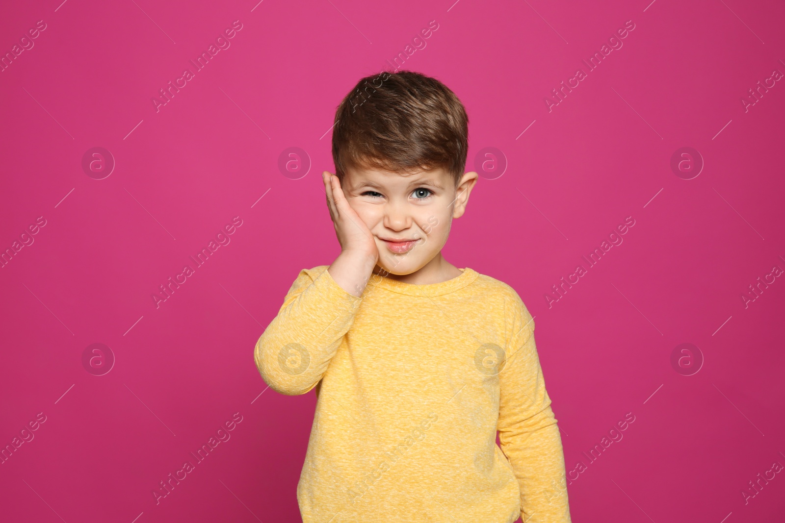 Photo of Little boy scratching face on color background. Annoying itch