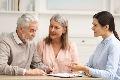 Notary consulting senior couple about Last Will and Testament in office