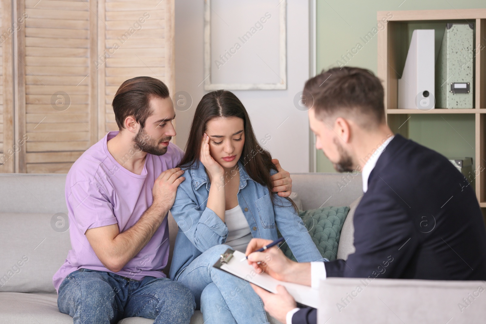 Photo of Family psychologist working with young couple in office