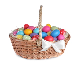 Wicker basket with bright painted Easter eggs on white background