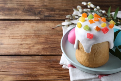 Beautiful Easter cake and painted eggs on wooden table. Space for text