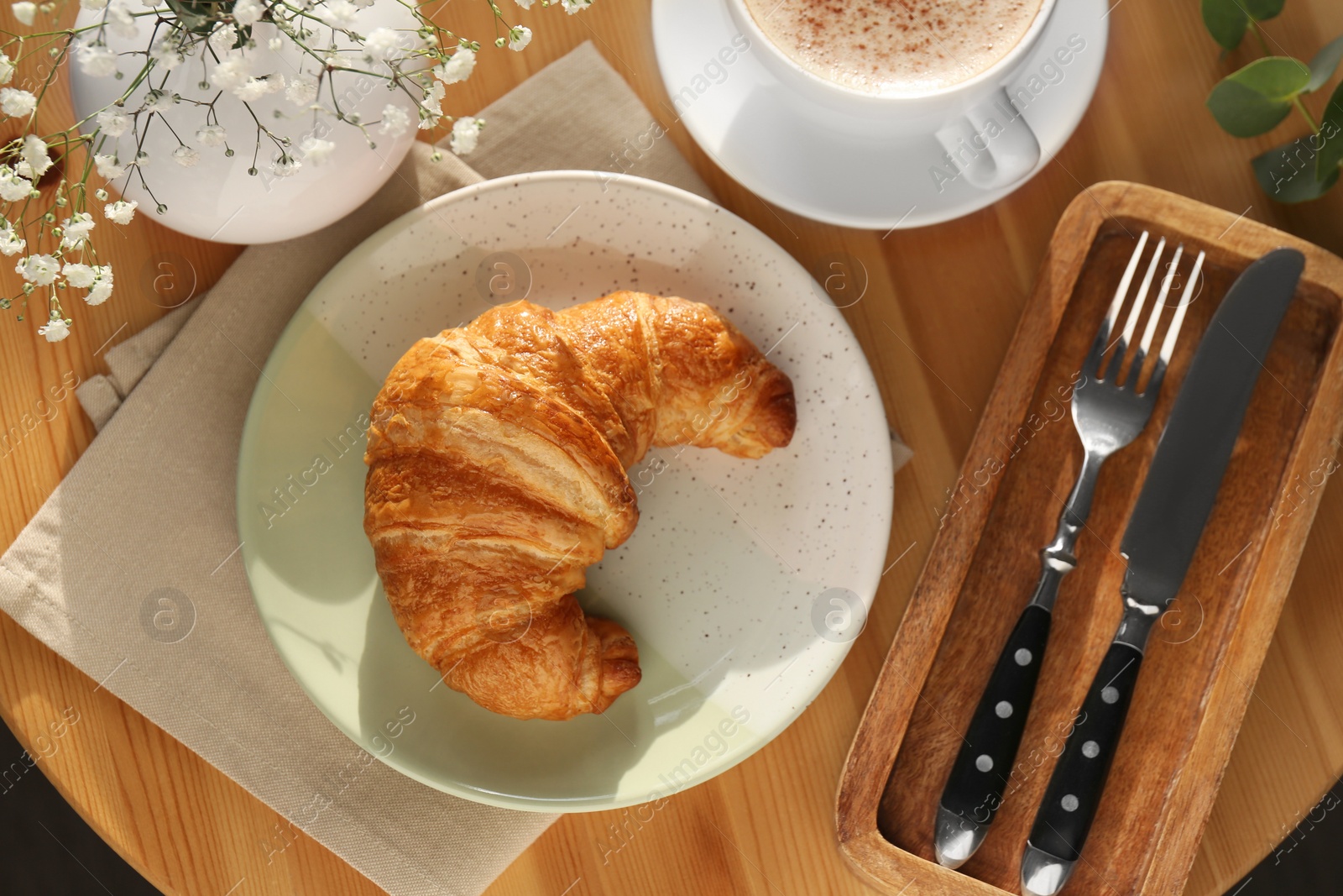 Photo of Tasty croissant served with coffee on wooden table, top view