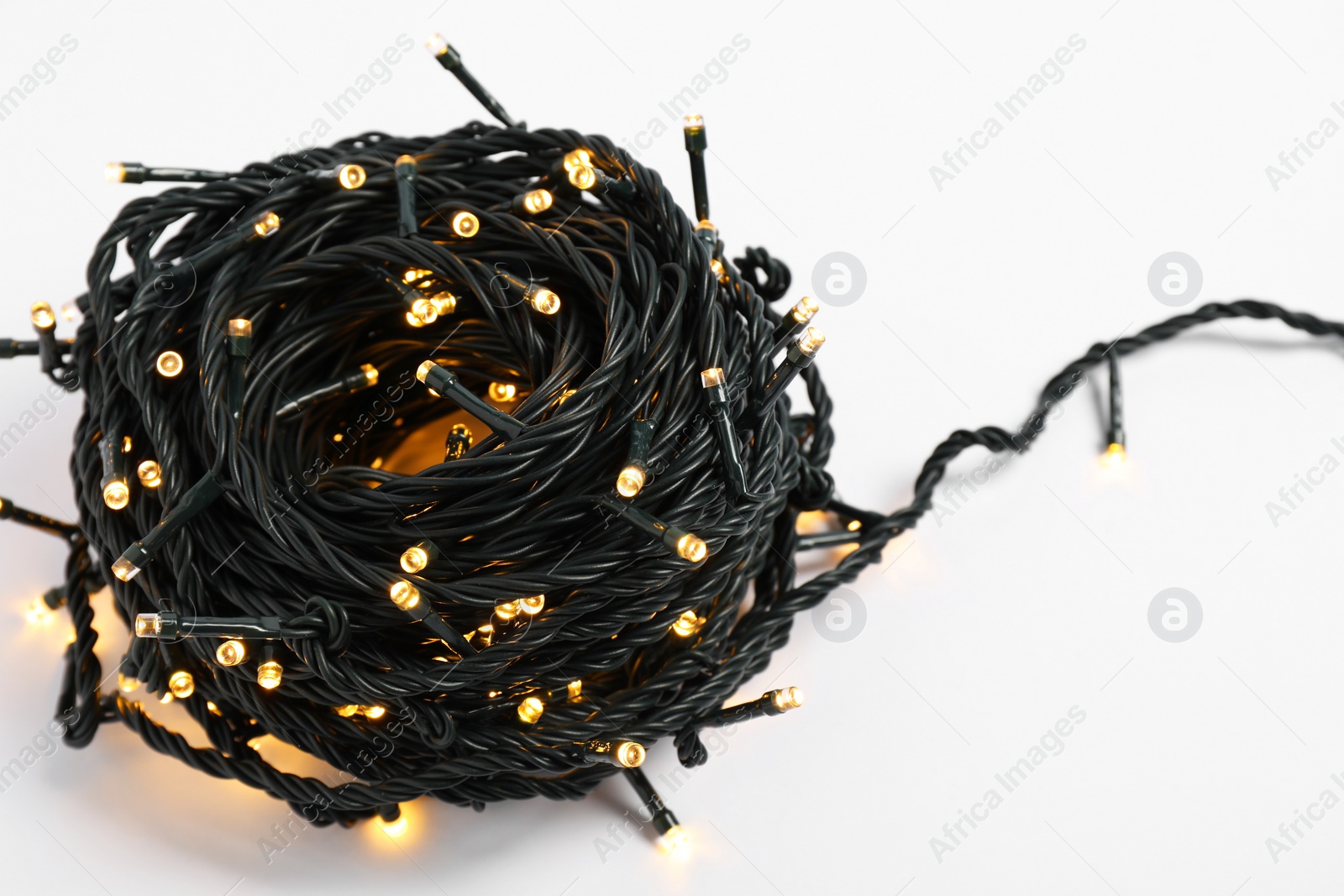 Photo of Beautiful Christmas lights on white background, closeup