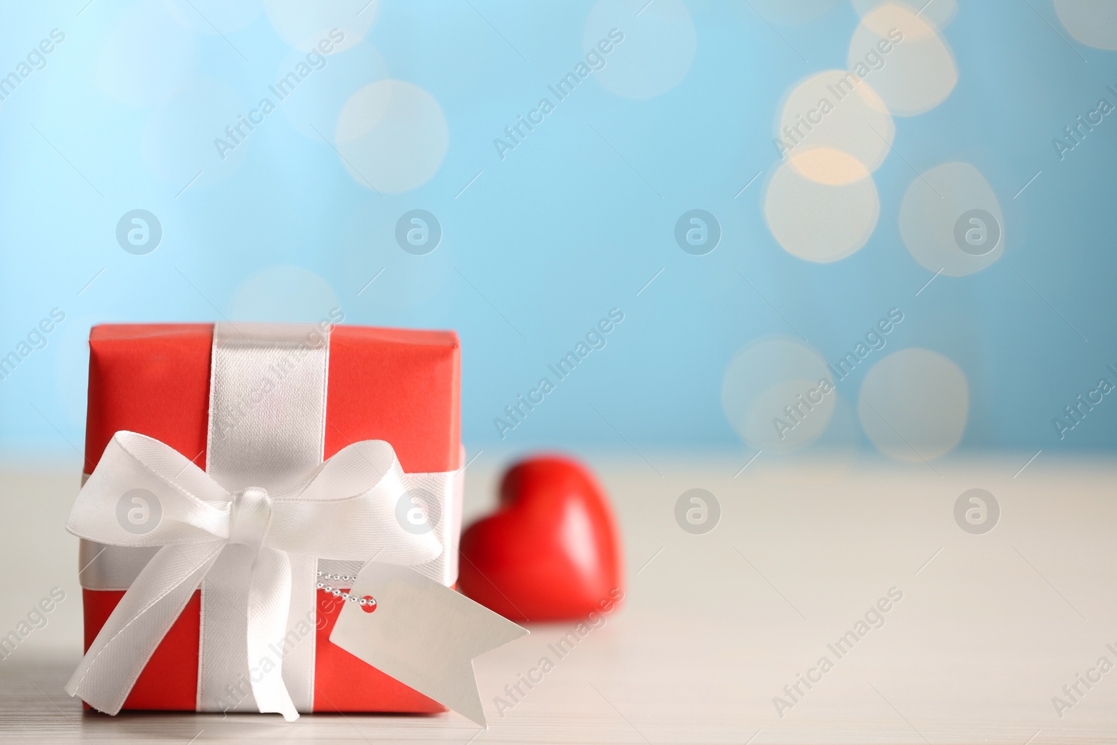 Photo of Beautiful gift box on light wooden table, space for text. Valentine's Day celebration