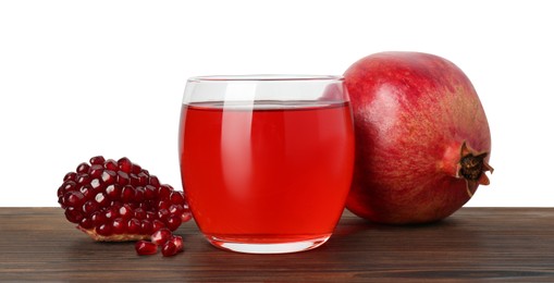 Photo of Refreshing pomegranate juice in glass, leaves and seeds on wooden table against white background