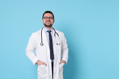 Photo of Smiling doctor on light blue background, space for text